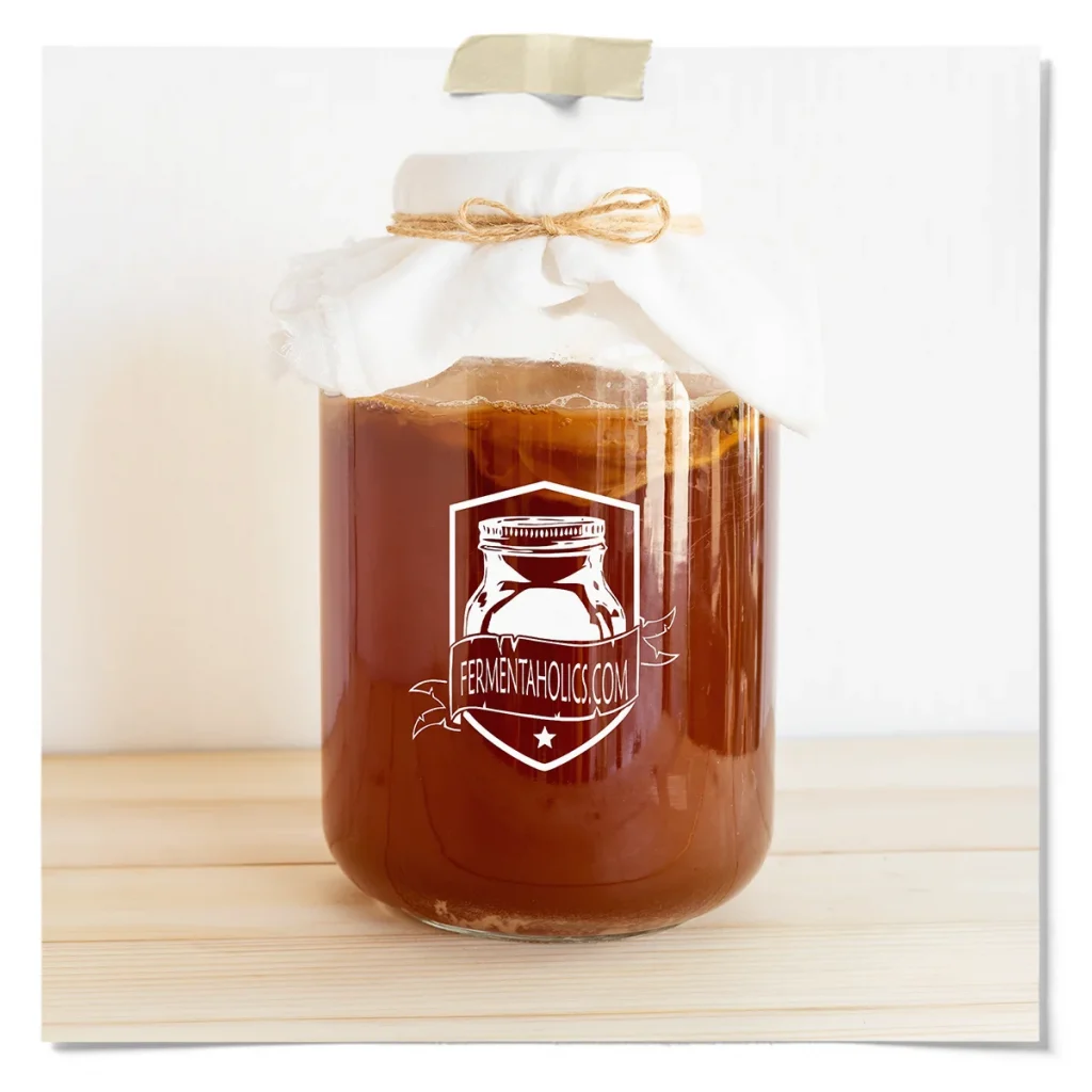 One-Gallon Kombucha Brewing Jar Covered With Breathable Cloth And Twine, Showing Fermenting Sweet Tea Ready For Primary Fermentation.