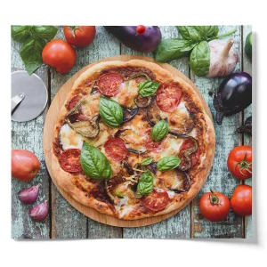 Homemade vegetable pizza topped with mozzarella, tomatoes, eggplant, bell peppers, and fresh basil, surrounded by fresh vegetables and herbs on a rustic wooden table.